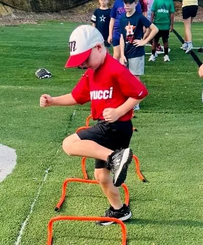 A camper running an agility hurdle drill
