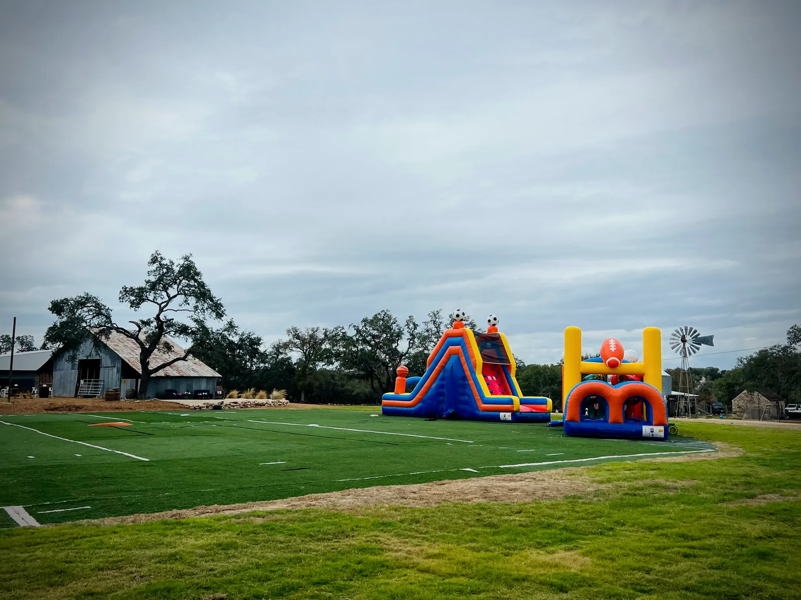 The open grounds at Revo Sports with the field and inflatables under a wide Texas sky