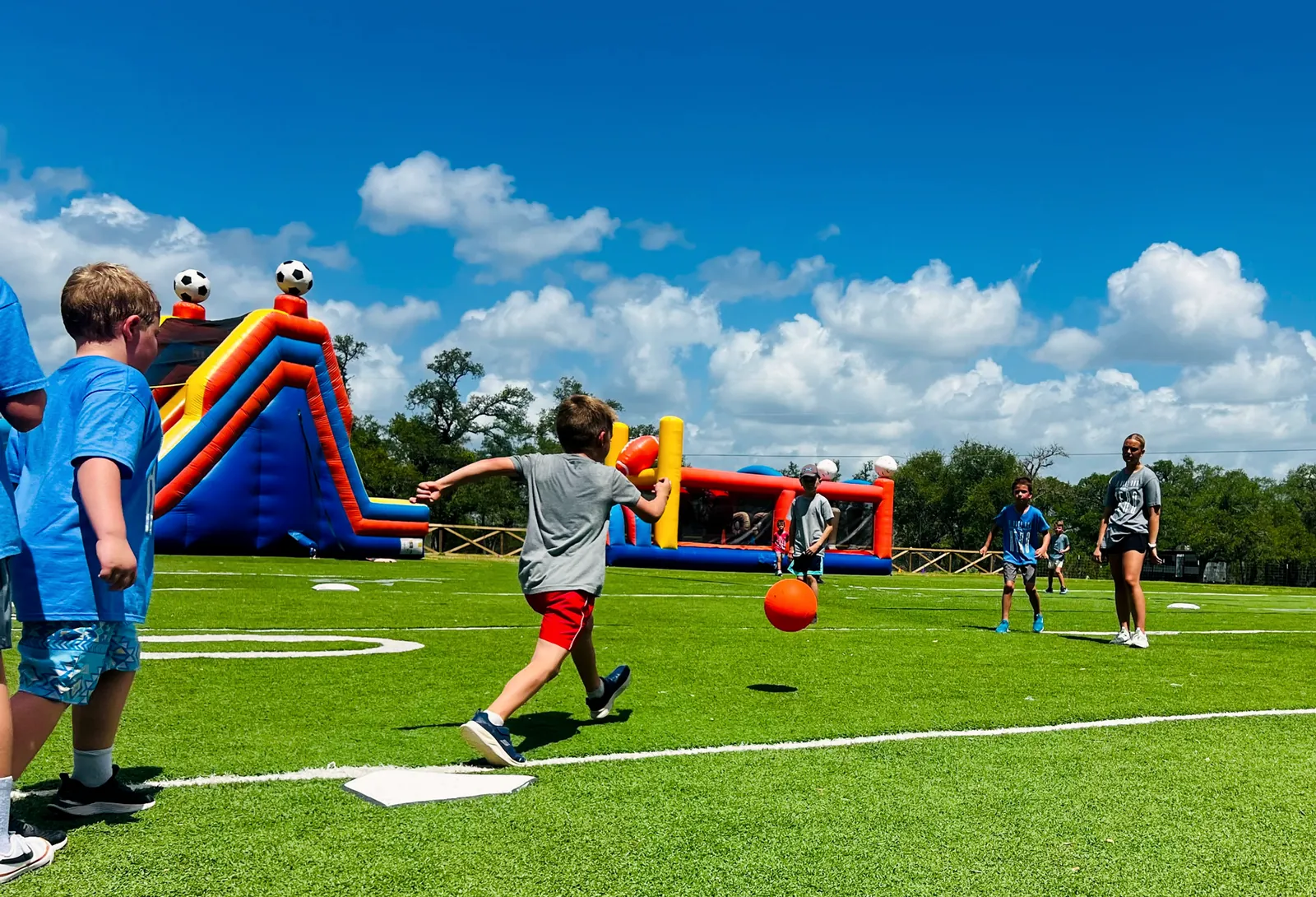Outdoor turf play area with inflatables at The Little League