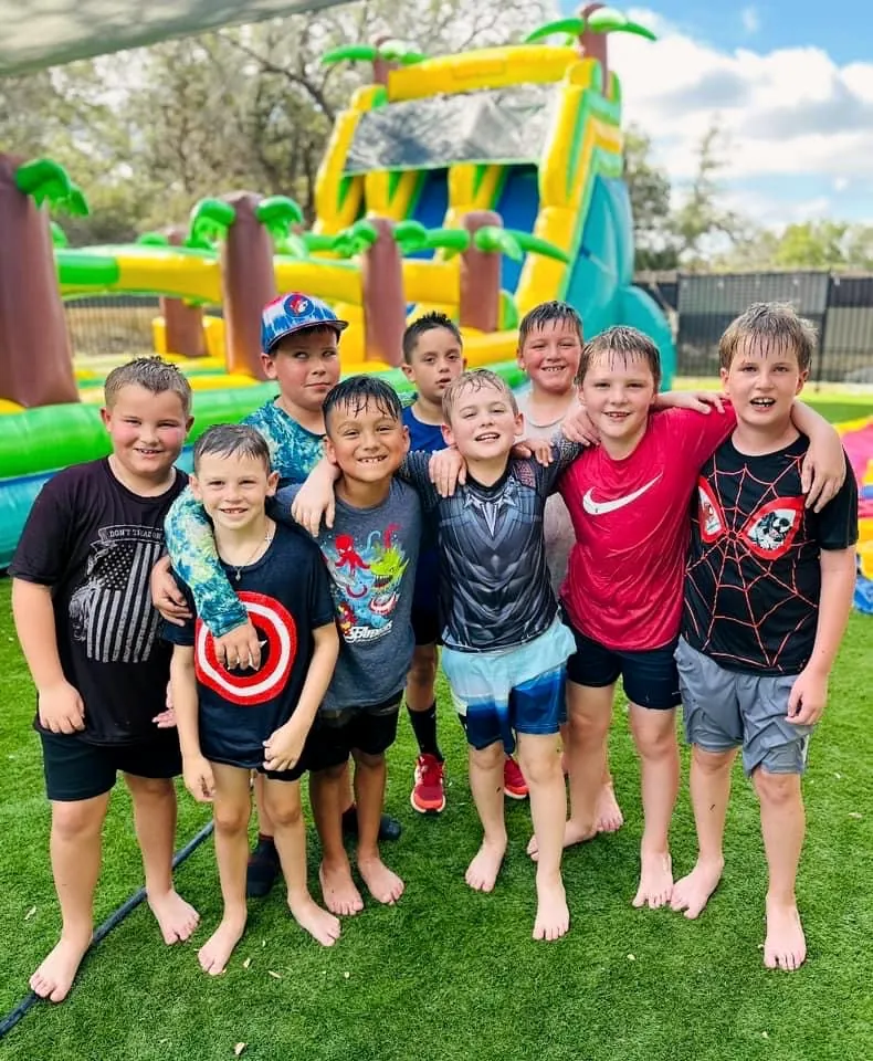 A group of children posing together in front of the inflatables after a party at Revo Sports