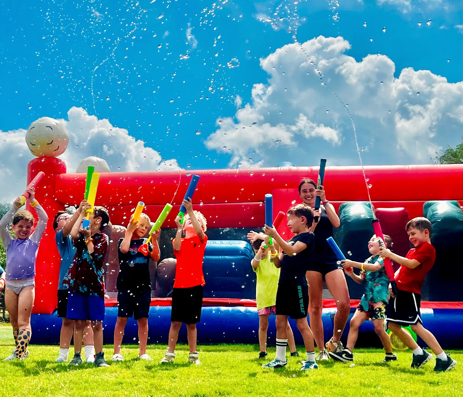 Children playing in a water battle on the turf at a Revo Sports birthday party