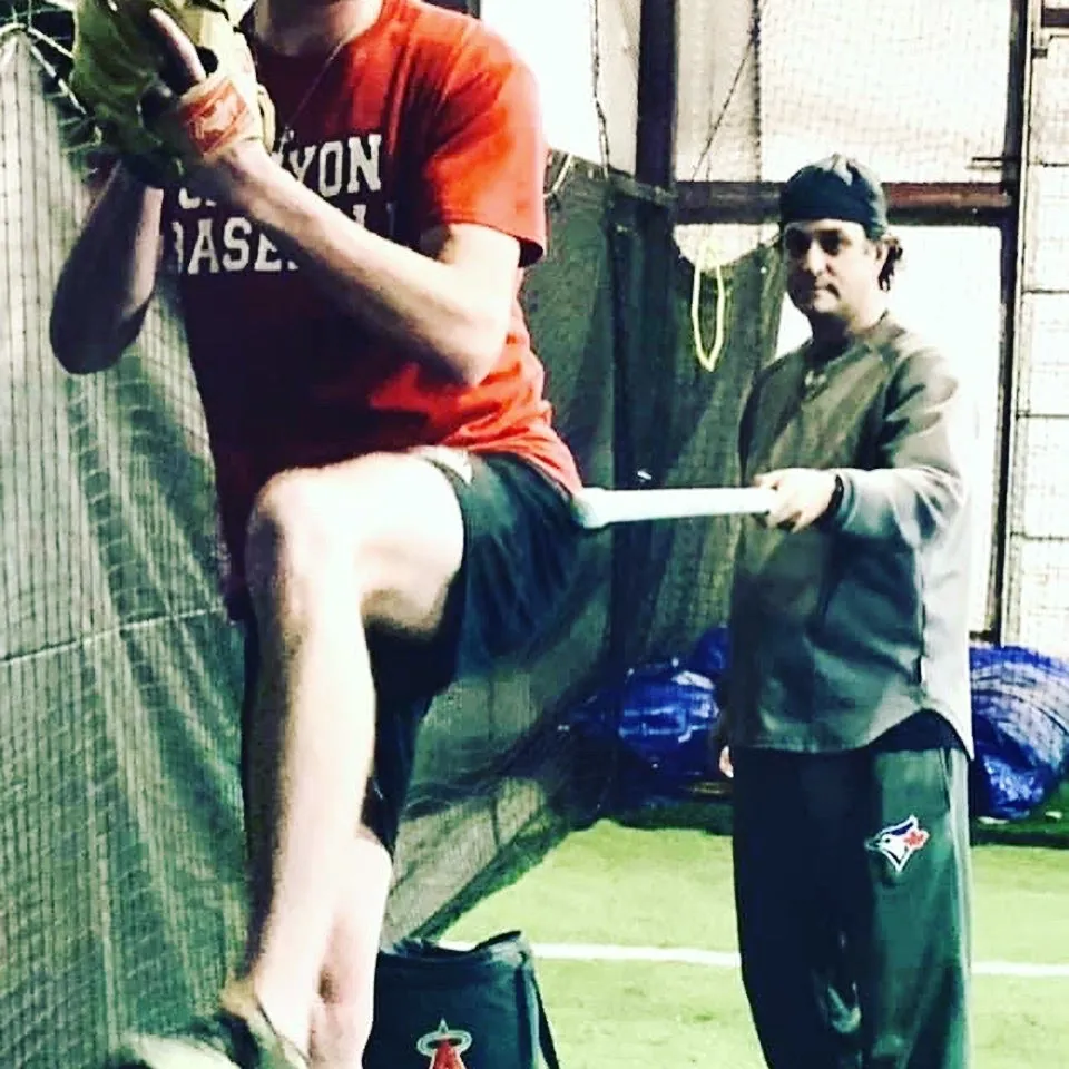 A young hitter working through a swing during baseball camp